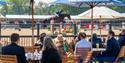 Royal Windsor Horse Show - people at tables under parasols watching showjumping