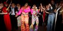 Haven’t Stopped Dancing Yet! - crowd dancing, two ladies in the middle wearing retro disco outfits