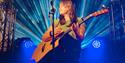 Jessie Reid performing on stage with acoustic guitar
