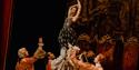 Manon - production shot - lady held up by a group of men in period dress