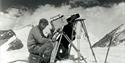 The Epic of Everest - sherpa filming on a snow capped mountain in black and white