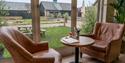 Table and two chairs in Windsor Farm Shop Café with view of Windsor Farm Shop