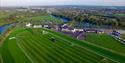 Aerial view of Royal Windsor Racecourse on the banks of the Thames, with Windsor Castle in the background