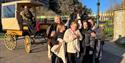 Family having a carriage ride on the Long Walk with Windsor Castle behind them