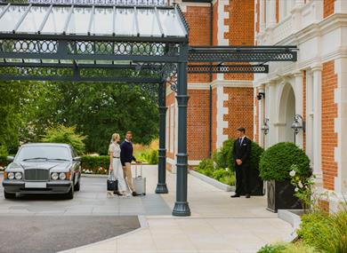 People walking into Fairmont Windsor Park, greeted by doorman