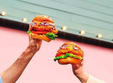 hands holding burgers in the air