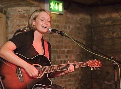 Sophie Henderson performing with guitar