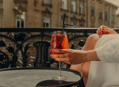 Person in bathrobe with a drink