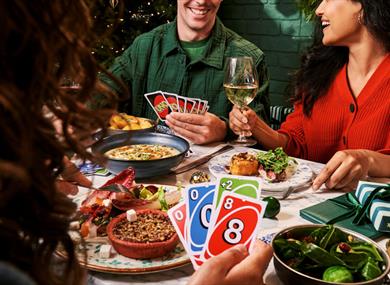 People eating round the table and playing cards
