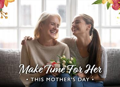 Daughter giving her mother a present and tulips