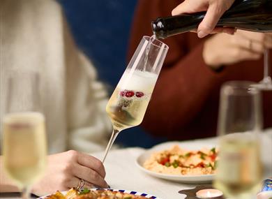Glass of pomegranate fizz being poured