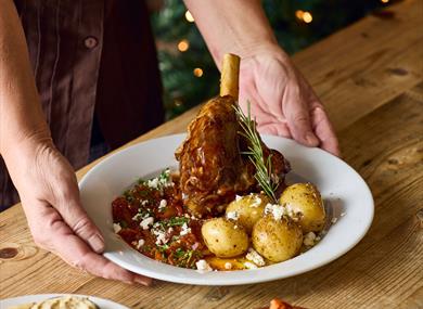 Plate of Christmas lamb on a table.