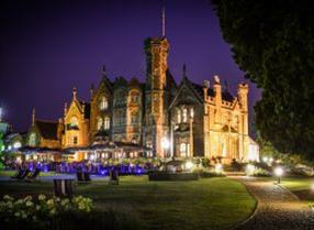The exterior of Oakley Court, a hotel in Windsor, lit up at night