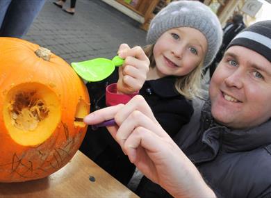 Father and daughter carving a pumpkin at Windsor Pumpkin Party
