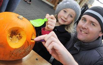 Father and daughter carving a pumpkin at Windsor Pumpkin Party