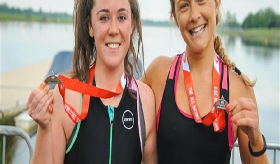 Two triathletes with their medals