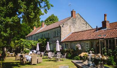 An image of The Pheasant Hotel - exterior and garden with seating