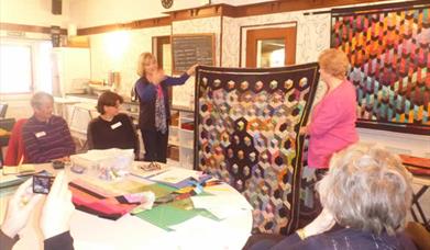 An image of people admiring a quilt at Bridlington Quilt sandwich