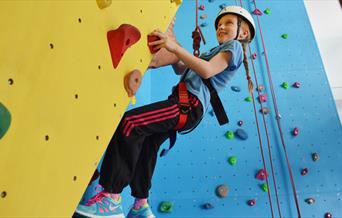A child on the climbing wall at East Riding Leisure, Bridlington in East Yorkshire.