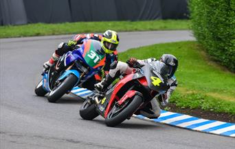 An image of 2 motorbikes racing round a bend on the track at Oliver's Mount racing