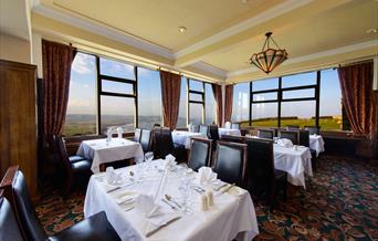 An image of inside dining room with tables set.