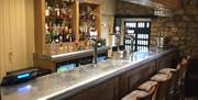 An image of inside the bar with tartan bar stools.