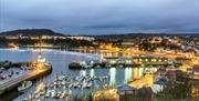 An image of Scarborough Harbour with street lights lit up