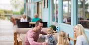 An image of a family sitting outside at Reighton Sands Holiday Park