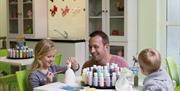 An image of a family doing some pottery painting at Reighton Sands Holiday Park