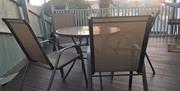 An image of Seagull Cottage patio with table and chairs on decking
