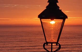 An image of a sunrise through a lamppost on North Bay, Scarborough