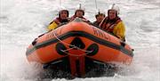 An image of four men on a RNLI speedboat near Scarborough Lifeboat Station
