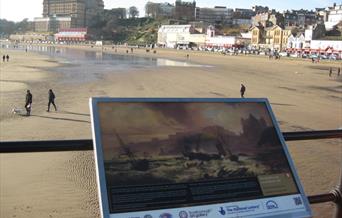 An image of information board with a view of Scarborough beach and coast.