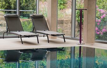 An image of The Raithwaite Estate Spa - lounge chairs by pool