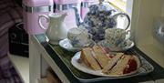 An image of a pot of tea and victoria sponge cake at Rosedale Light Shepherds Hut