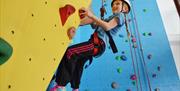 A child on the climbing wall at East Riding Leisure, Bridlington in East Yorkshire.