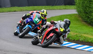 An image of 2 motorbikes racing round a bend on the track at Oliver's Mount racing