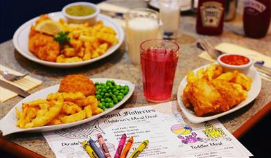 An image of fish and chips plated with a kids colouring sheet at Royal Fisheries