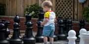 An image of a little boy playing giant chess
