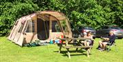 An image of a family relaxing outside their tent at Robin Hood Caravan Park