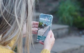 An image of a person using the Love Exploring Trails app.