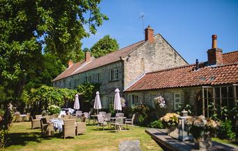 An image of The Pheasant Hotel - exterior and garden with seating