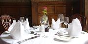 An image of a fine dining table with white table cloth