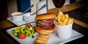 An image of plated burger and chips meal
