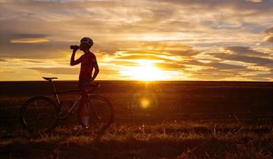 An image of a cyclist at sunset