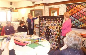 An image of people admiring a quilt at Bridlington Quilt sandwich